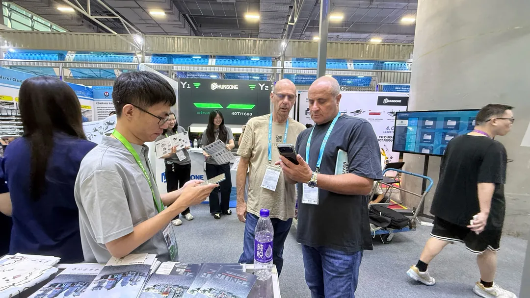 ZENITH staff showing project information on a phone to buyers at the booth