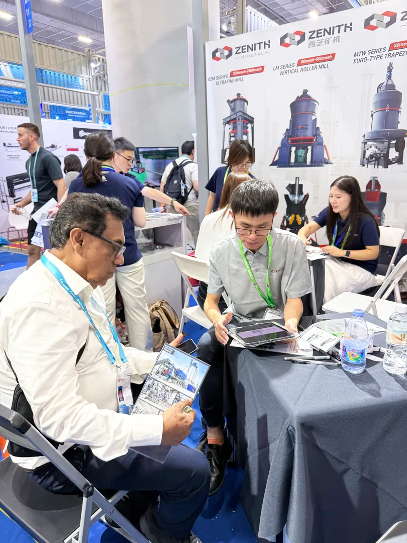 Buyer reading a ZENITH project case-study brochure at the booth