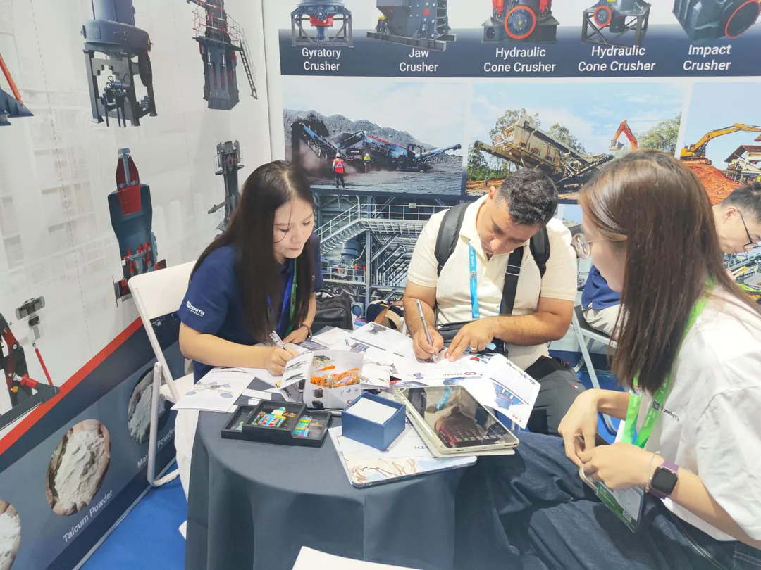 Visitor completing an enquiry form with ZENITH staff at the booth