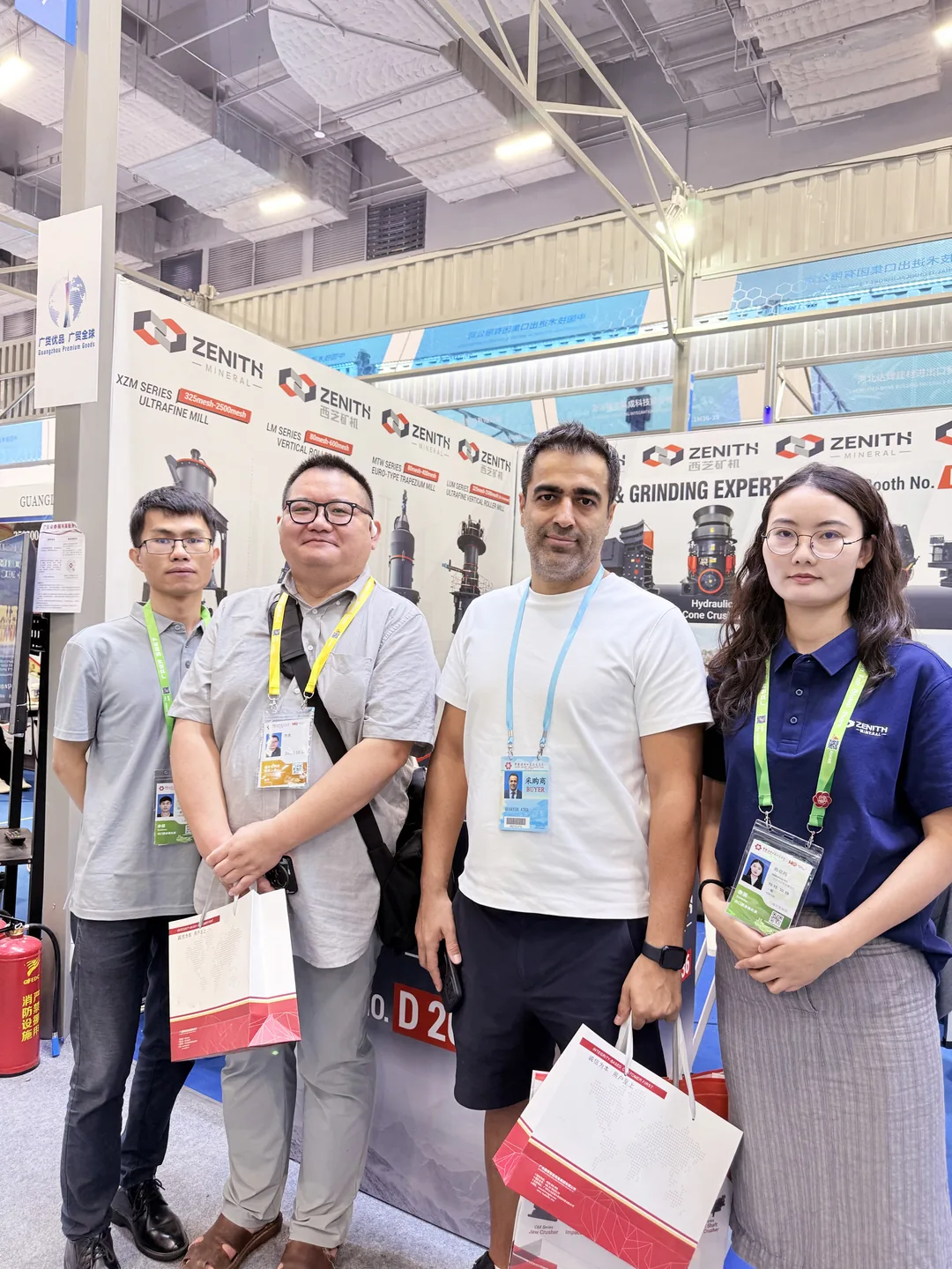 ZENITH staff and visitors in front of the full product wall at the booth