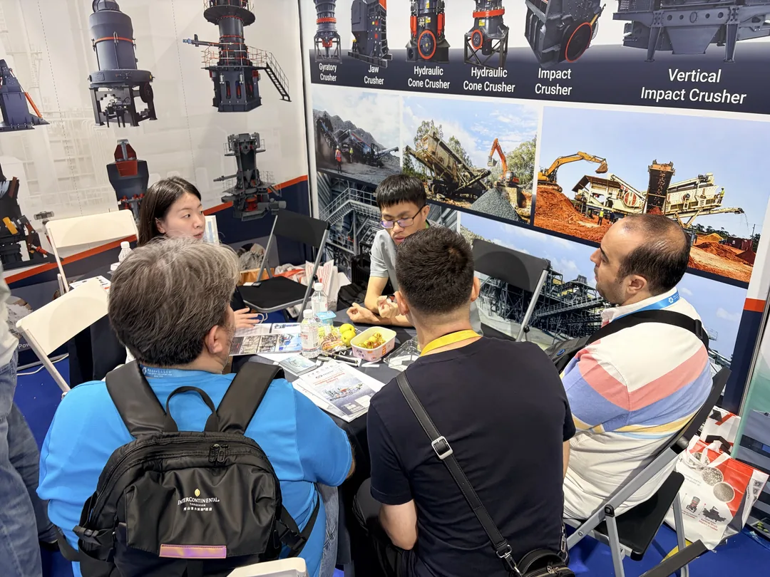 Discussion between a ZENITH representative and European visitors at the booth table