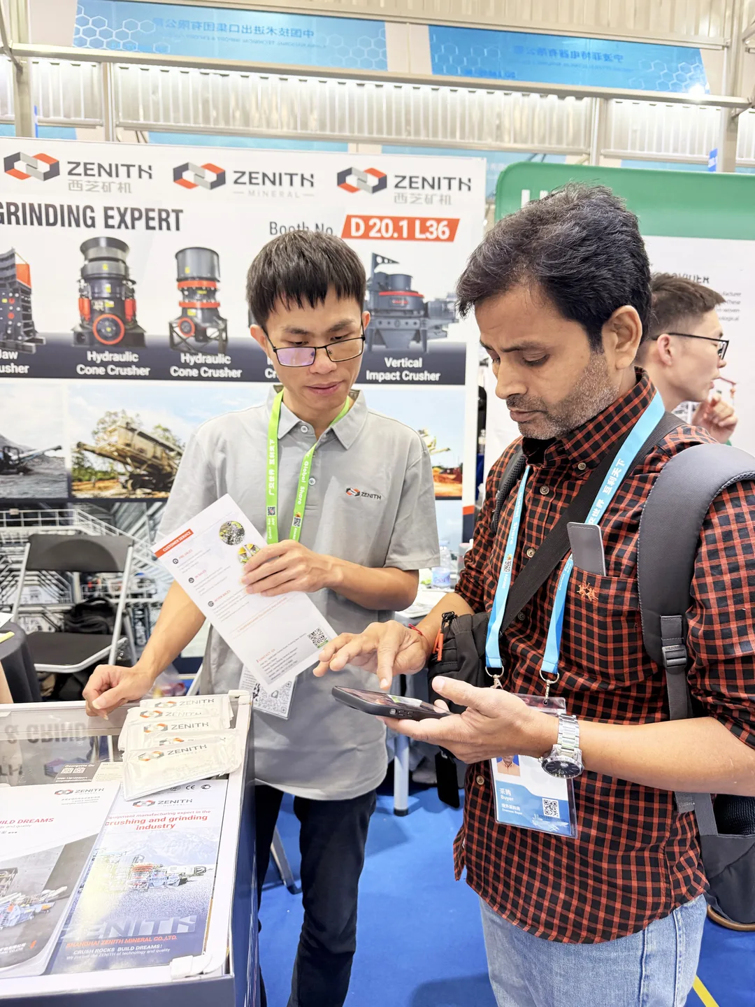 ZENITH engineer reviewing a grinding mill specification sheet with a visitor